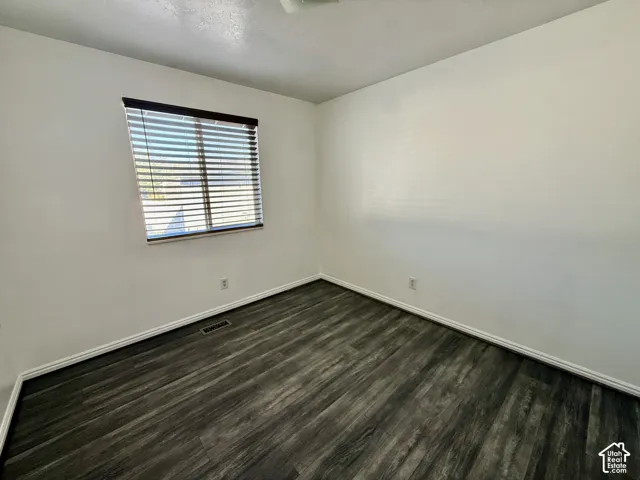 Room featuring neutral wall finishes and wood-finish flooring with horizontal blinds