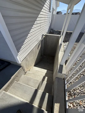 Exterior concrete staircase with retaining walls and white vinyl siding