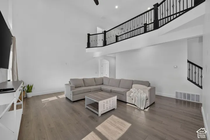 Vaulted ceilings, wood-finish flooring, and black metal stair railings