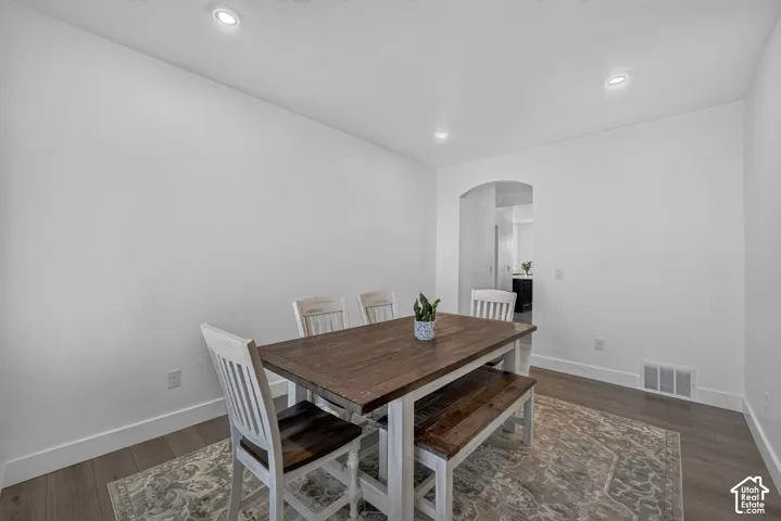 Neutral-toned wood-finish flooring, recessed lighting, and a distinct arched doorway