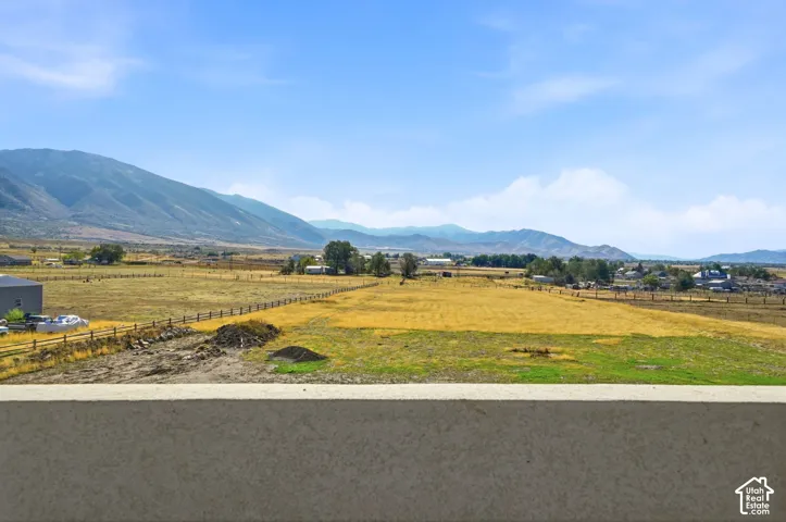Expansive open land featuring mountain scenery and post-and-rail fencing