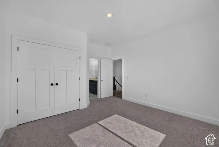 Interior room featuring neutral-toned carpeting, recessed ceiling lighting, and double-panel doors with matte black hardware