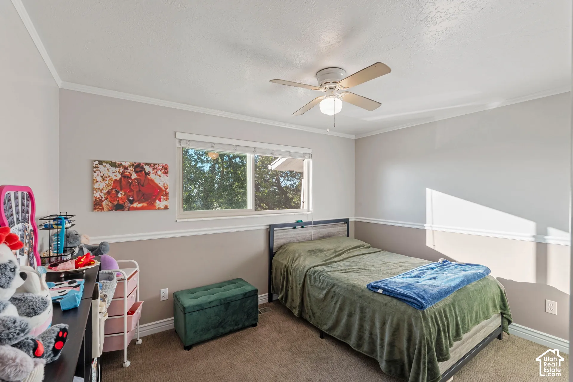 Neutral-toned room featuring two-tone wall paint with a chair rail, carpeting, a ceiling fan with integrated lighting, and a single-pane horizontal window