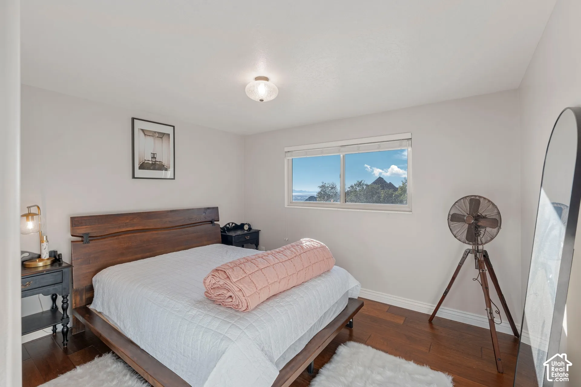 Wood-finish flooring, neutral wall tones, flush-mount ceiling lighting, and a window framing exterior mountain scenery