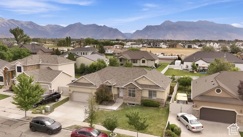 Single-story residence featuring a stone and stucco facade, a multi-gabled roofline, an attached two-car garage, and mountain scenery