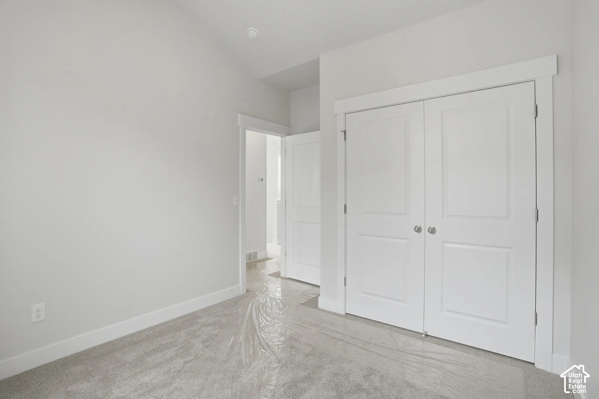 Vaulted ceilings, neutral wall palette, double-door closet with shaker-style panels, and interior doors featuring clean-lined trim