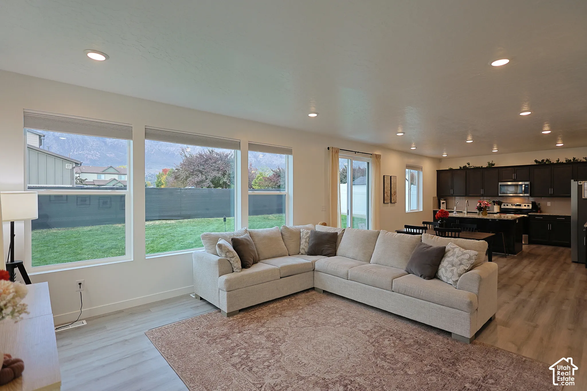 Open-concept interior featuring wood-finish flooring, recessed lighting, and large picture windows