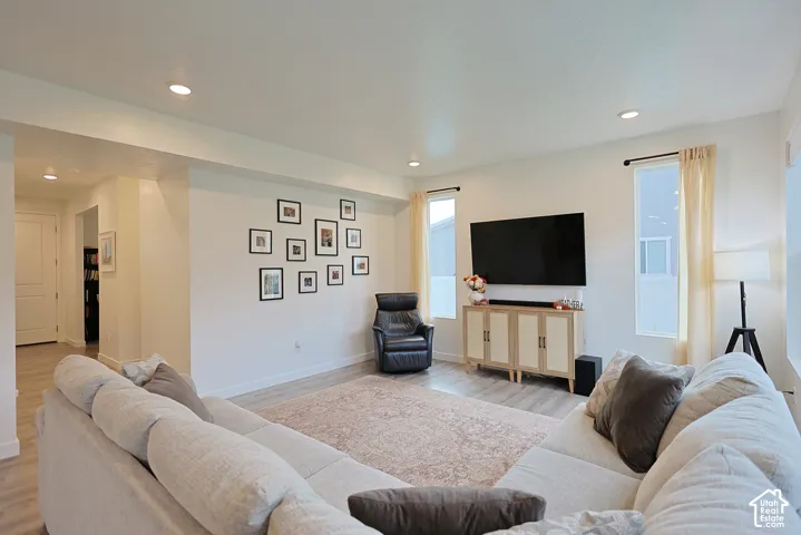 Living area featuring neutral wall tones, recessed lighting, and wood-finish flooring