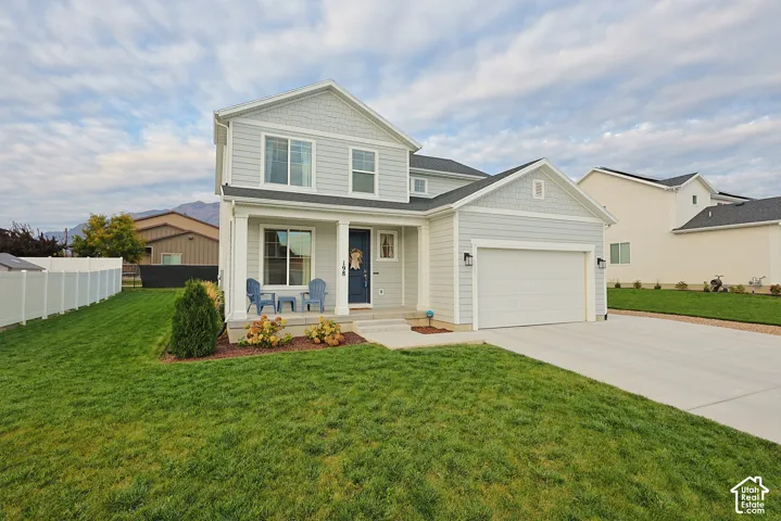 Two-story exterior featuring light-gray horizontal lap siding, a combination of shingle and horizontal facade accents, a covered front porch with white columns, and an attached two-car garage