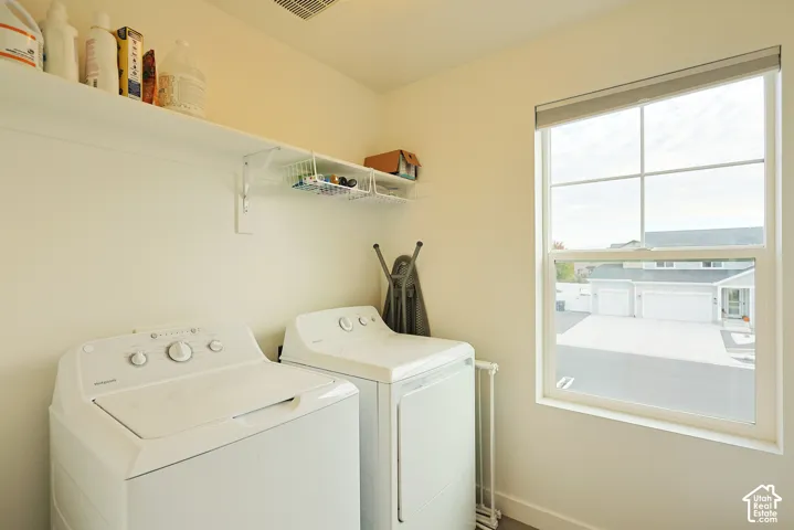 Laundry space featuring a single-hung window with a grid pattern and integrated upper shelving with wire organizers