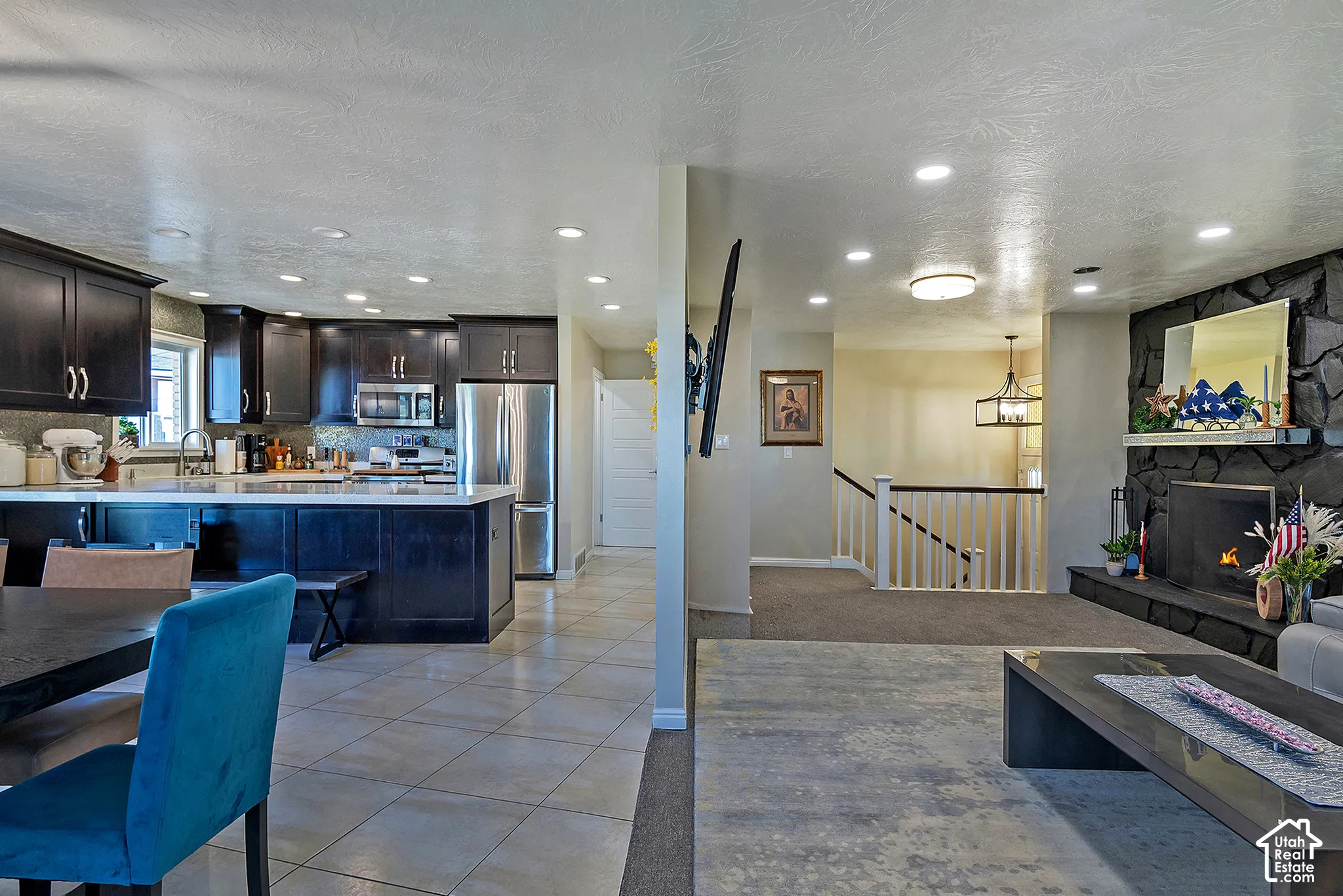Kitchen featuring dark wood cabinetry, stainless steel appliances, and a central island with a stone countertop