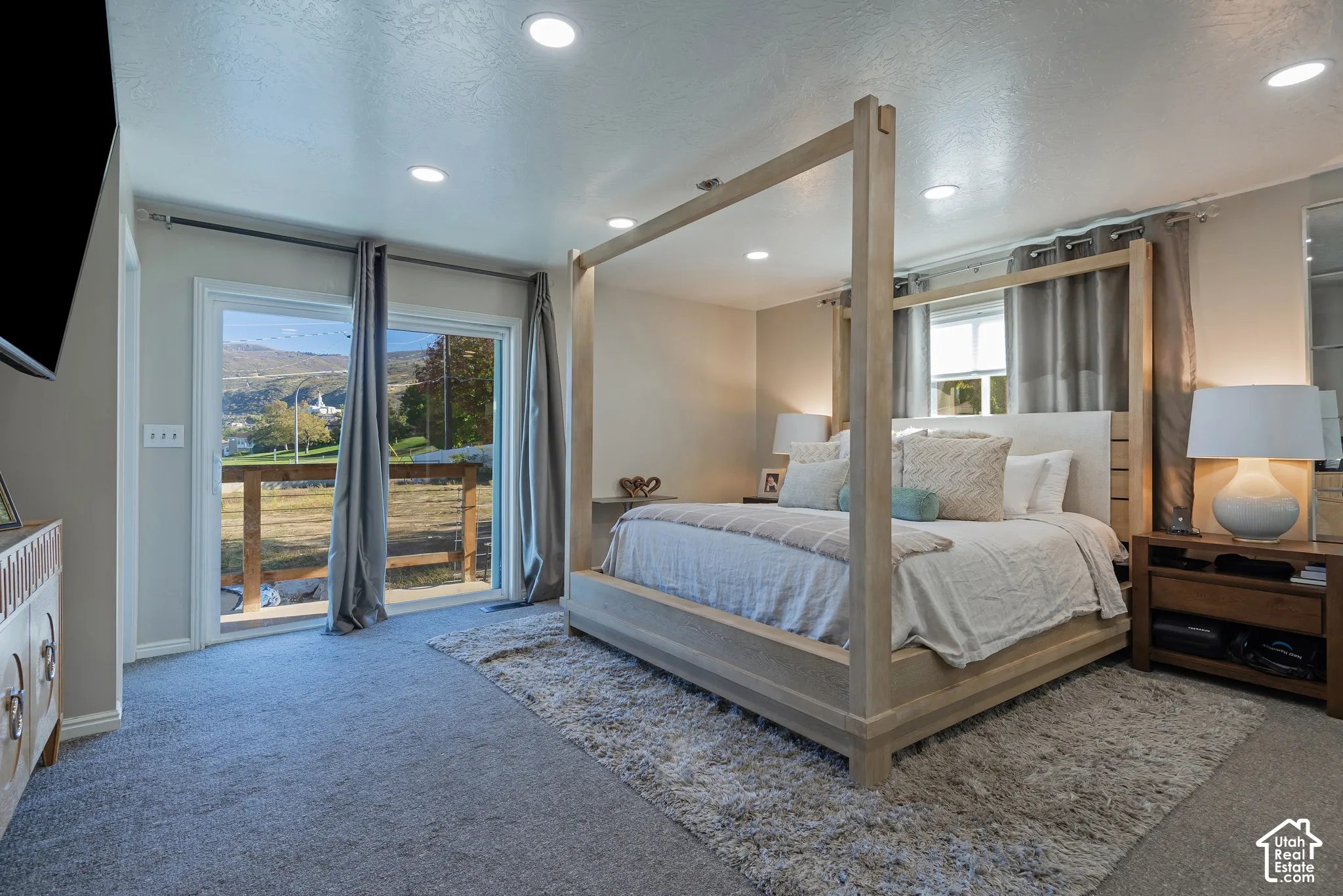 Sliding glass door with exterior deck access, recessed ceiling lighting, carpeted flooring, and mountain backdrop