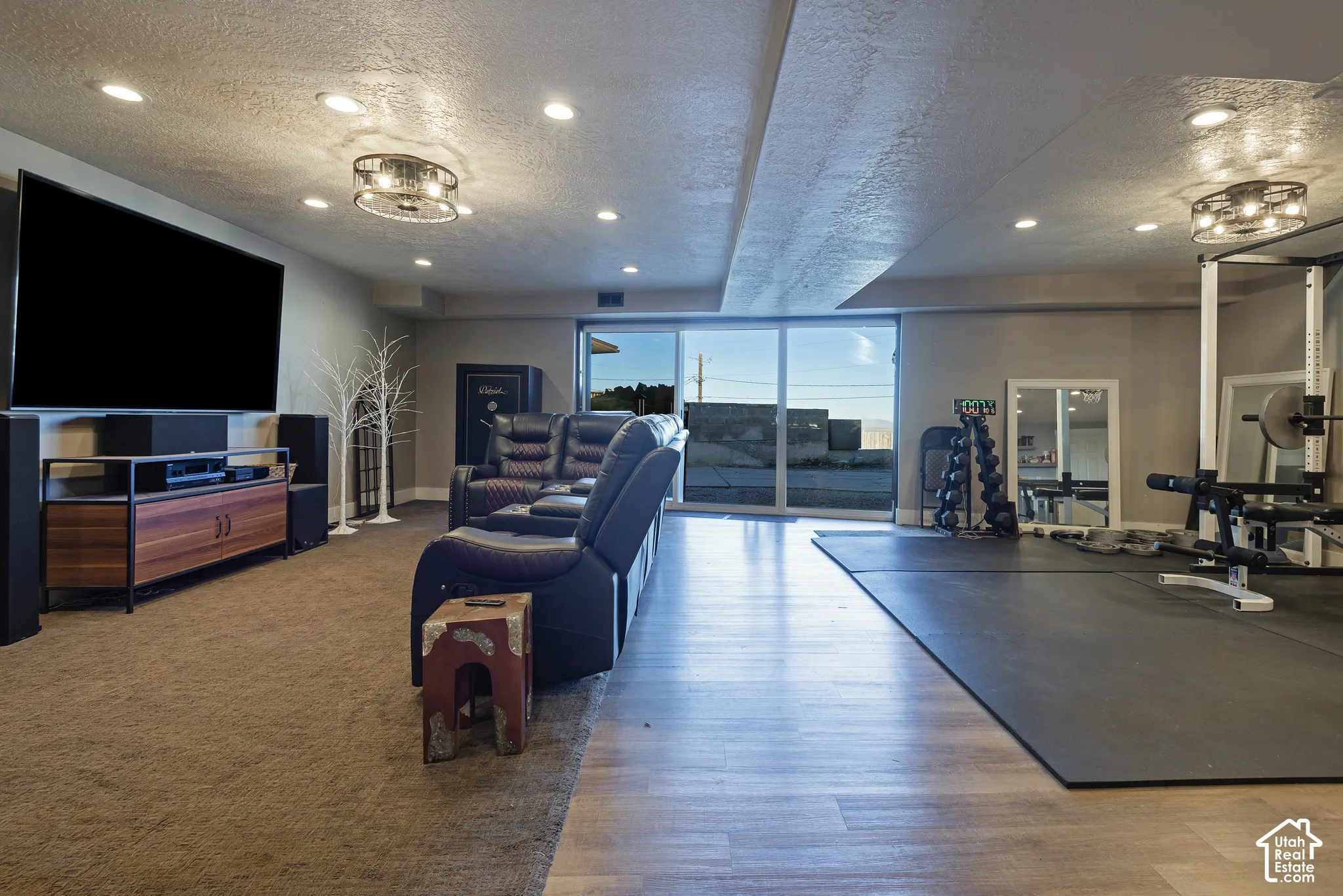Multi-purpose room featuring recessed lighting, dual drum-style ceiling fixtures, wood-finish flooring, and large sliding glass doors