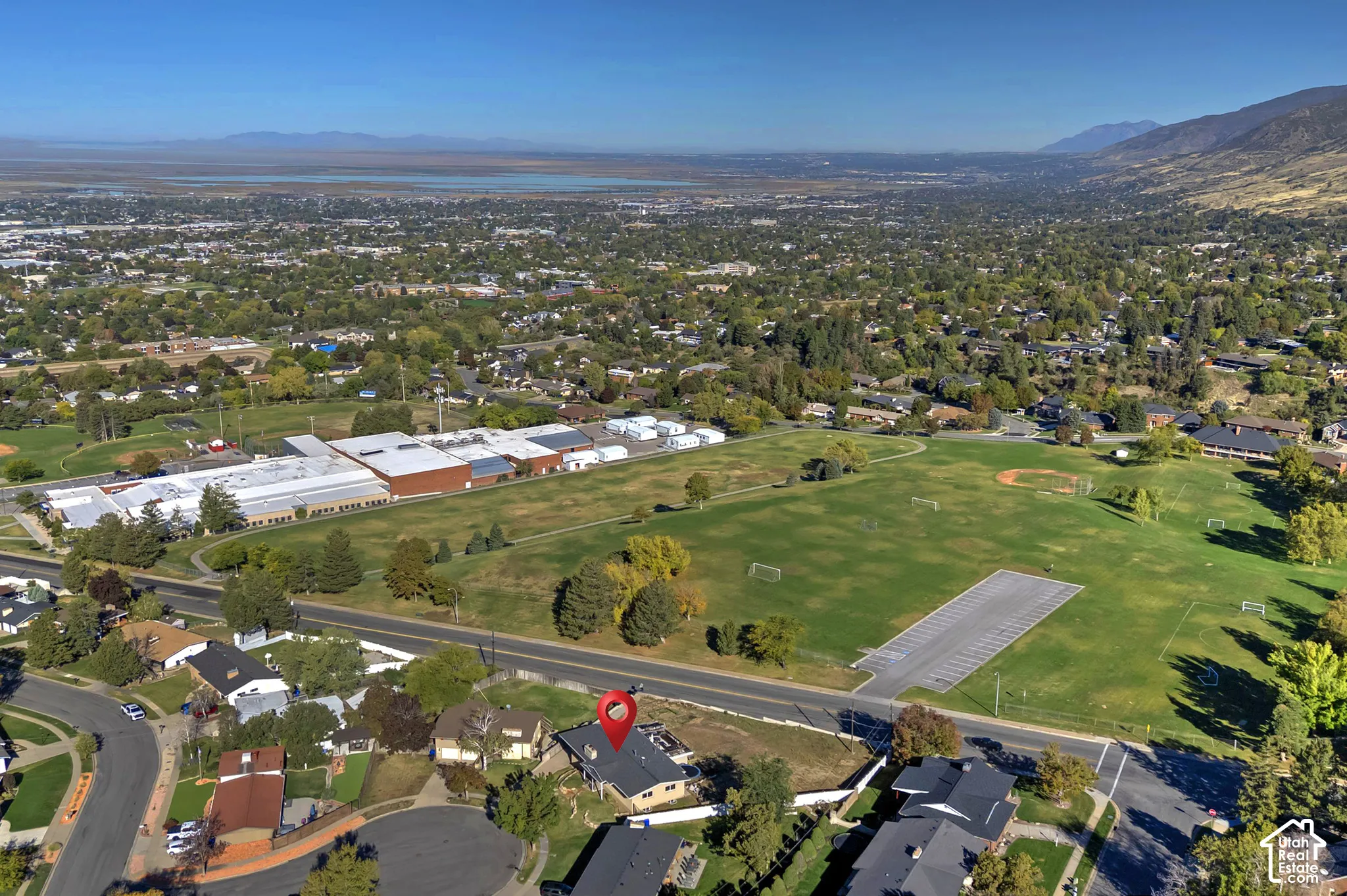 Aerial perspective highlighting property location with extensive grounds, mature tree canopy, and mountain backdrop