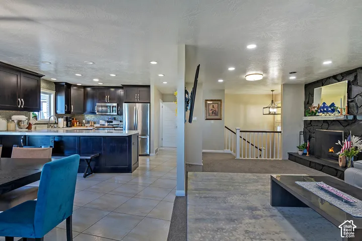 Kitchen featuring dark wood cabinetry, stainless steel appliances, and a central island with a stone countertop
