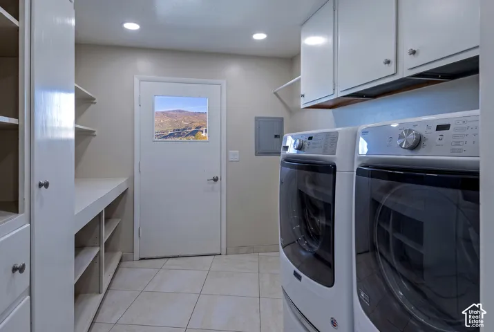 Laundry room featuring tile flooring, built-in cabinetry, an integrated folding counter, and a door with a window showcasing mountain scenery