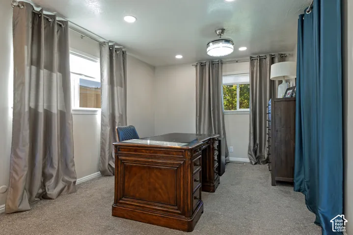 Interior room featuring wall-to-wall carpeting, recessed ceiling lighting, a flush-mount light fixture with an integrated ceiling fan, and multiple windows