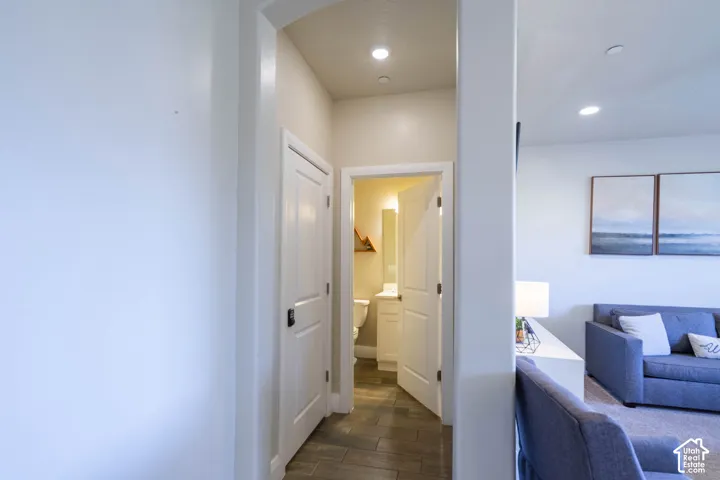 Neutral-toned walls, recessed lighting, wood-finish flooring, and white paneled doors