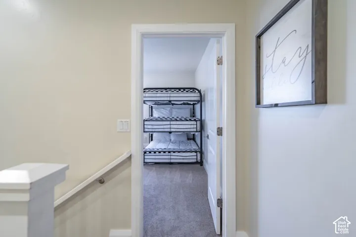 Neutral-toned walls with crisp white door casing, solid-core interior door, and wall-mounted handrail with painted post