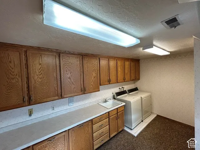 Upstairs Laundry with Oak cabinetry, extended  countertop, and integrated utility sink