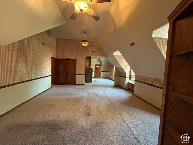 Upstairs Master Bedroom Vaulted ceilings featuring two ceiling fans, wood-finish doors, and custom dormer windows