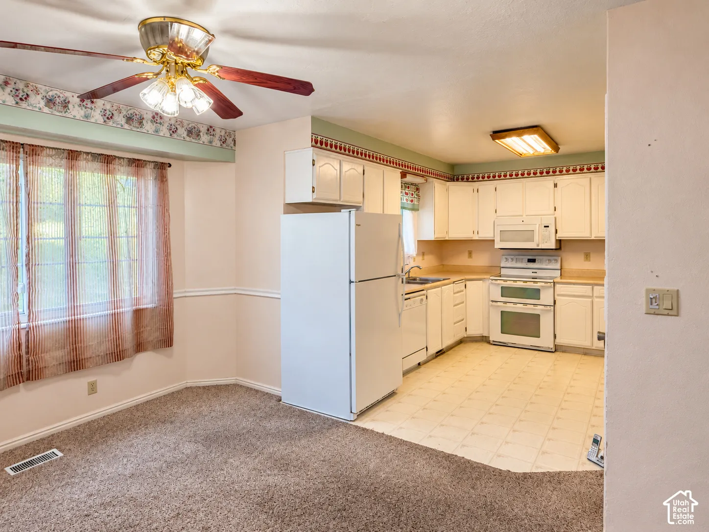 Kitchen featuring white cabinetry, integrated white appliances, a double-oven range, and tiled flooring