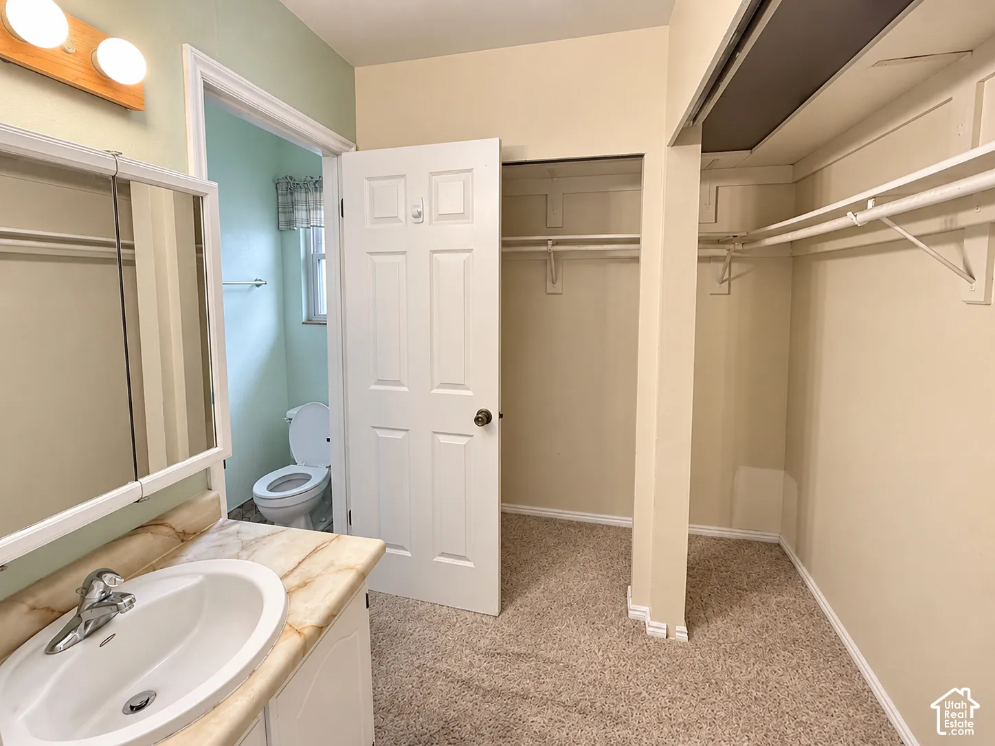 Vanity featuring an integrated sink, stone-finish countertop, and wall-mounted three-light fixture