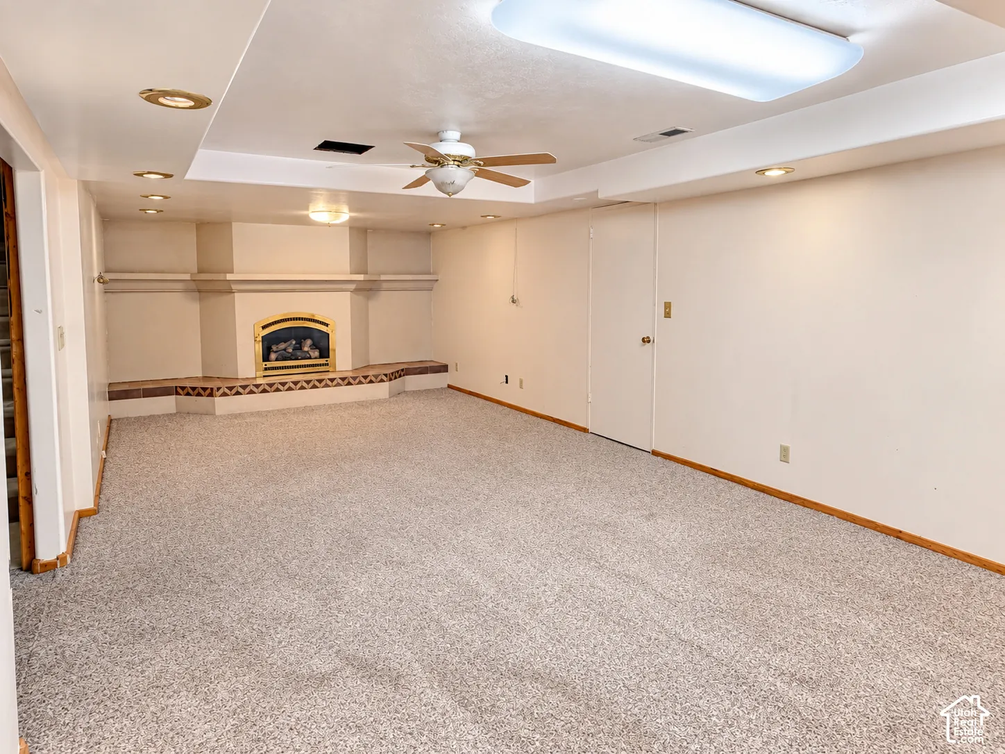 Fireplace with raised tile hearth, ceiling fan, recessed lighting, and wall-to-wall carpeting