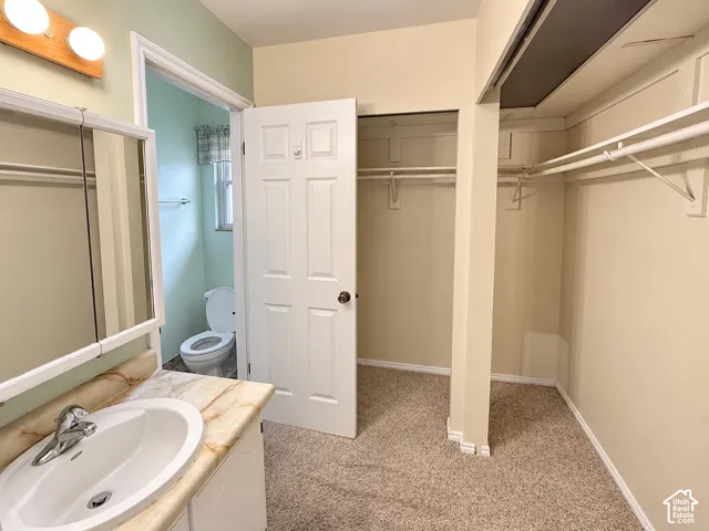 Vanity featuring an integrated sink, stone-finish countertop, and wall-mounted three-light fixture