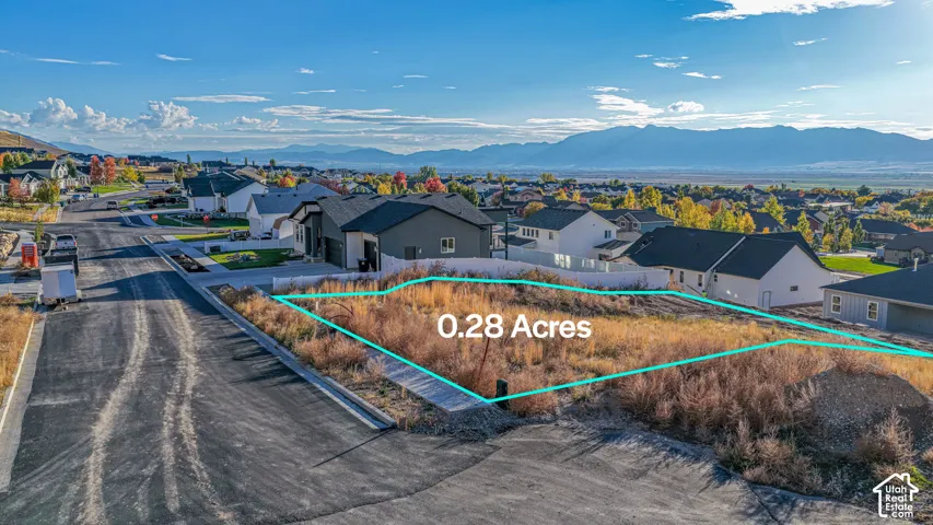 Residential lot spanning 0.28 acres featuring asphalt road frontage, curb-and-gutter infrastructure, and mountain topography in the distance