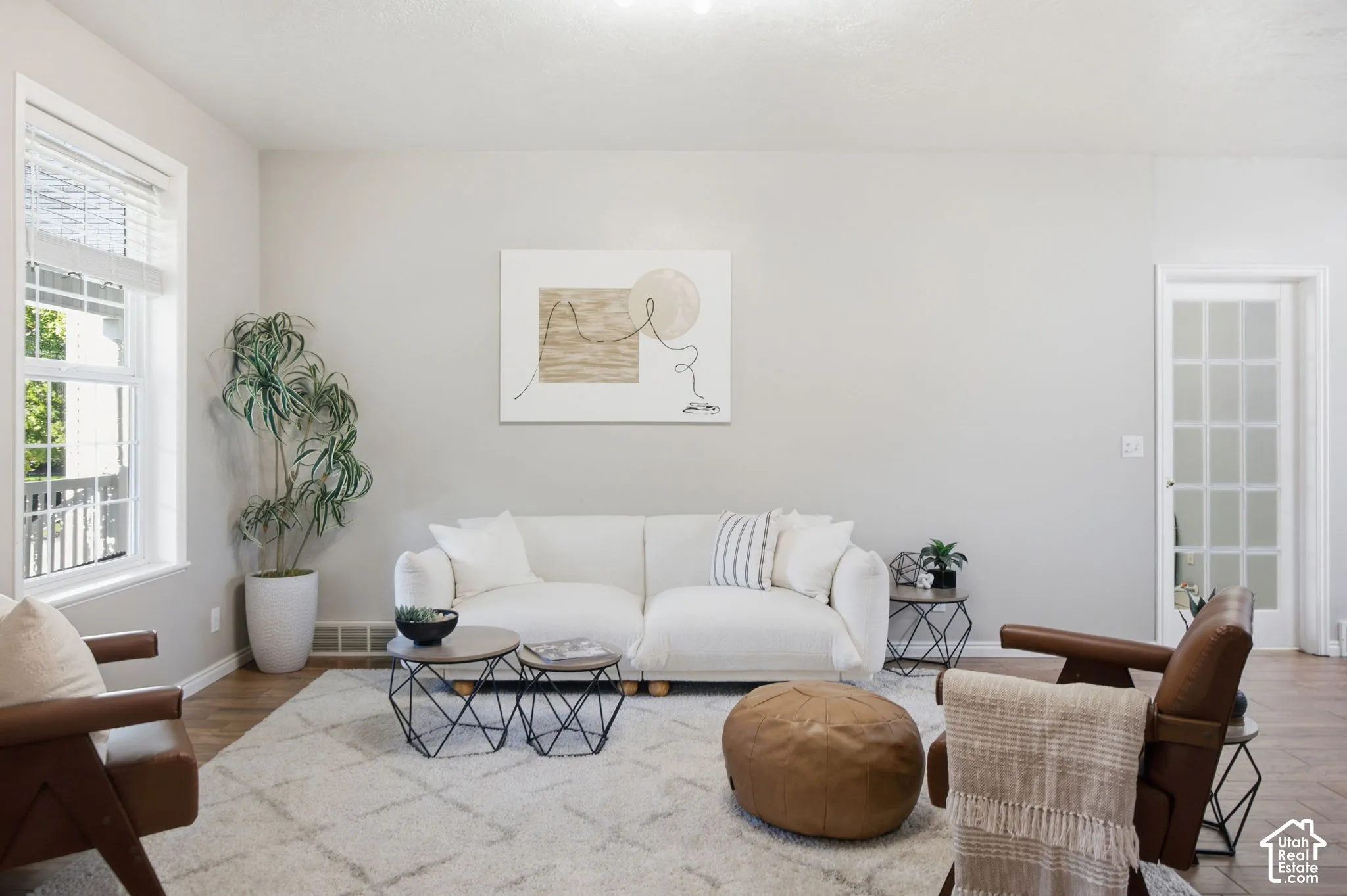 Neutral-toned walls, wood-finish flooring, multi-pane glass door, and a dual-pane window