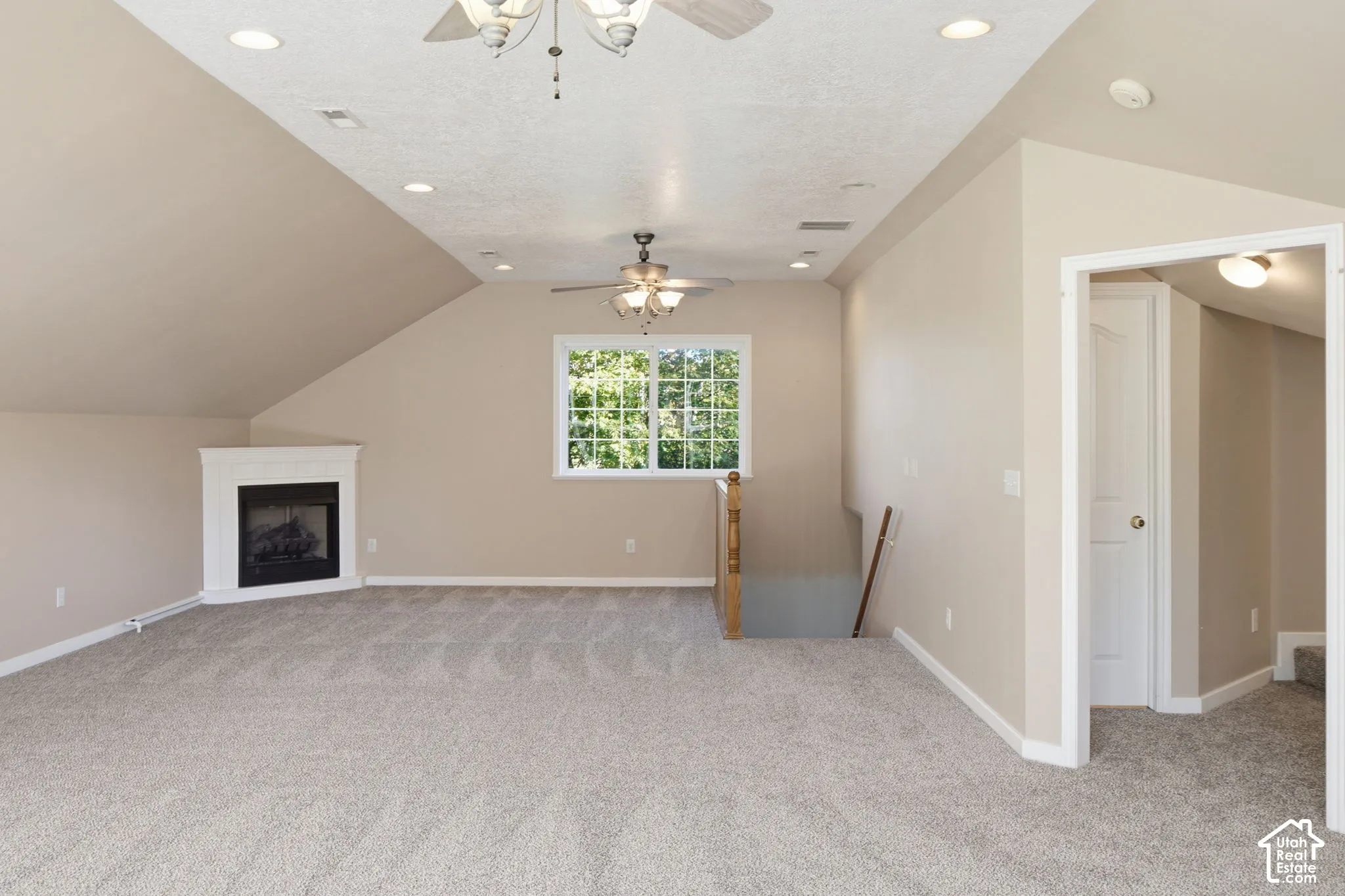 Vaulted ceilings, carpeted flooring, corner gas fireplace, recessed lighting, and dual ceiling fans
