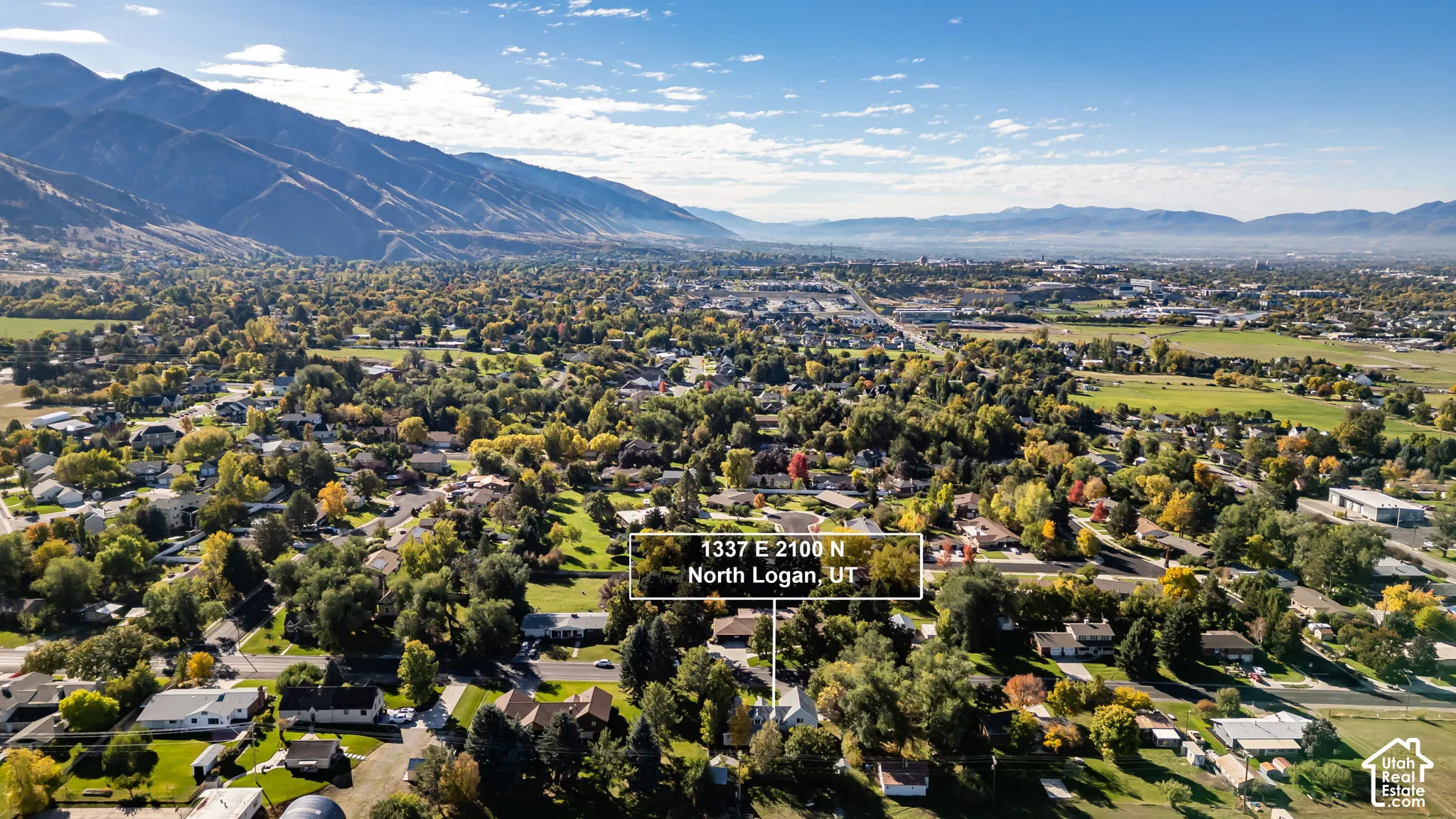 Aerial perspective of the residential lot highlighting mature trees and mountainous terrain backdrop