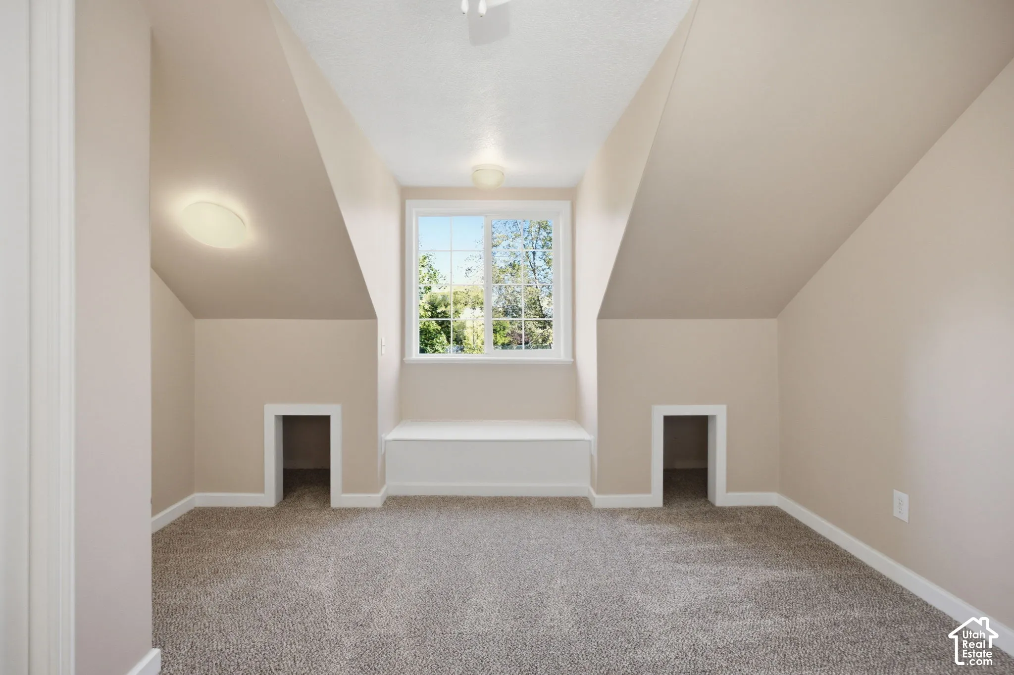 Vaulted ceiling, built-in window seat, dual recessed nooks, and wall-to-wall carpeting