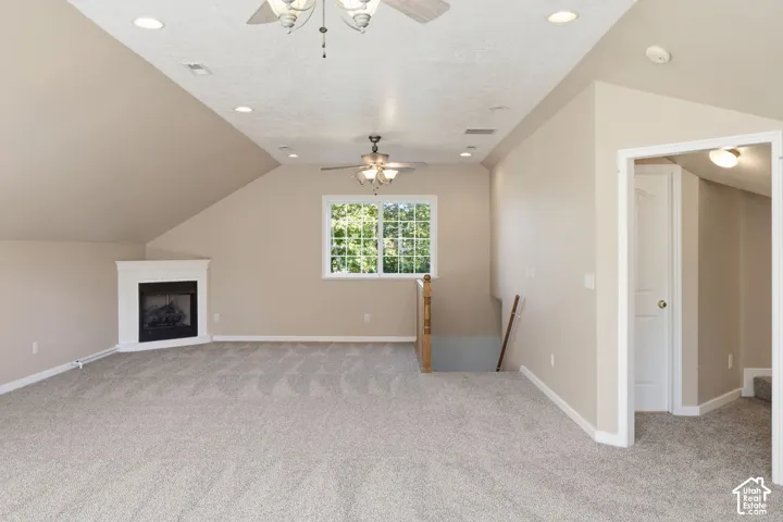 Vaulted ceilings, carpeted flooring, corner gas fireplace, recessed lighting, and dual ceiling fans