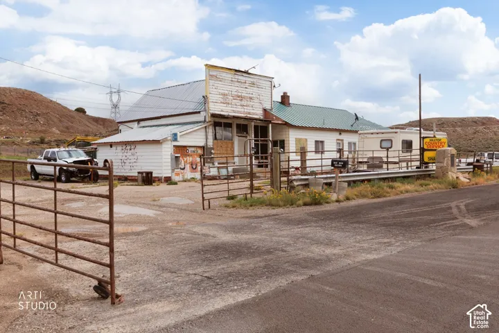 Commercial structure featuring a metal roof, horizontal siding, and a metal-gated gravel access point