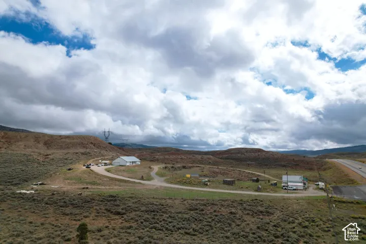 Expansive acreage featuring rugged desert topography, an established gravel access road, and two detached structures