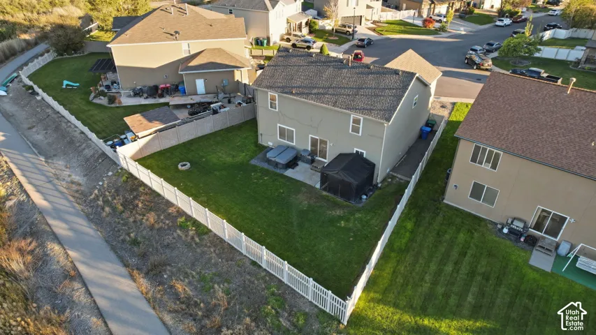 Two-story residence featuring a fully fenced backyard, concrete patio, asphalt shingle roof, and exterior siding