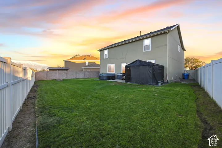 Backyard featuring a concrete patio, perimeter vinyl fencing, and mountain backdrop