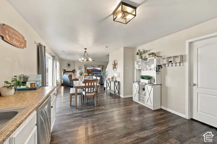 Wood-finish flooring throughout, dual flush-mount and chandelier lighting fixtures, built-in cabinetry with barn-door style hardware, and a solid-core interior door