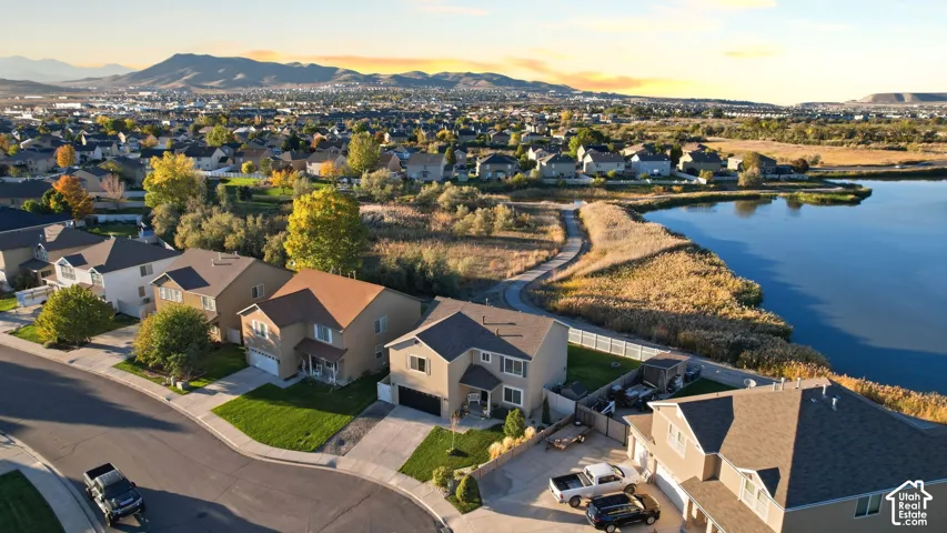 Aerial perspective featuring proximity to a waterfront, paved walking trails, and expansive mountain scenery