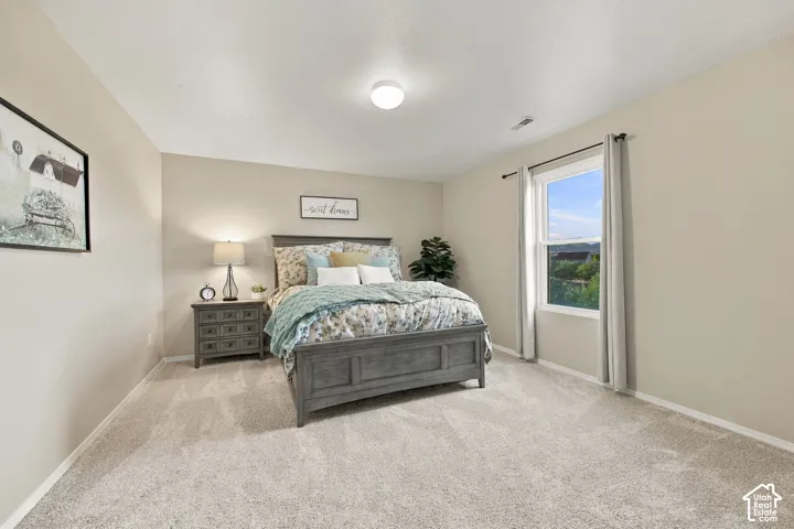 Neutral-toned interior space featuring wall-to-wall carpeting, a single-hung window, and a flush-mount ceiling light fixture