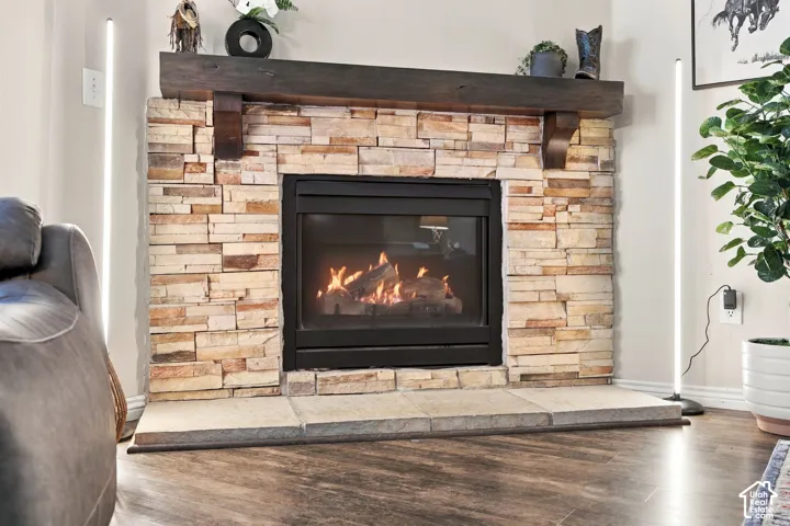 Fireplace featuring floor-to-ceiling dry-stack stone surround, substantial dark wood mantel with corbel detailing, and wide stone hearth