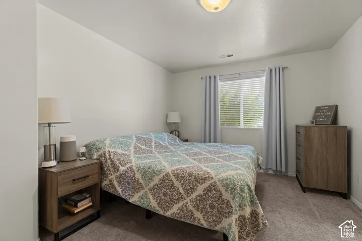 Neutral interior room featuring neutral wall paint, carpeted flooring, a single-window configuration with horizontal blinds, and a semi-flush mount ceiling fixture