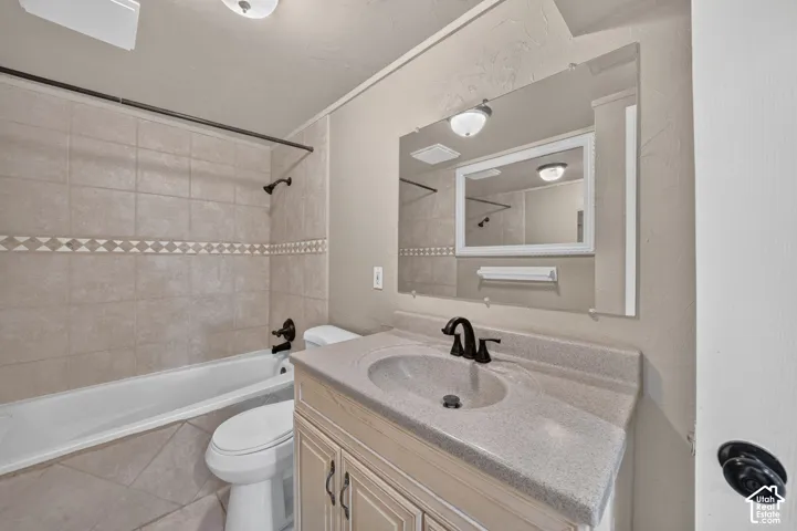 Bathroom featuring a vanity with an integrated basin, stone-composite countertop, oil-rubbed bronze faucet, and a large wall-mounted mirror