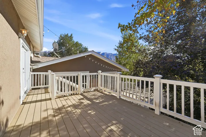 Elevated exterior deck featuring composite decking, white balustrade railing, and mountain backdrop