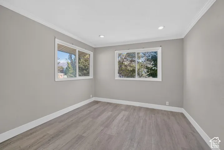 Neutral-toned interior featuring wood-finish flooring, dual sliding windows, and recessed lighting