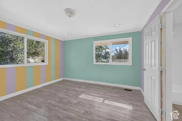 Room featuring wood-finish flooring, recessed lighting, and large windows