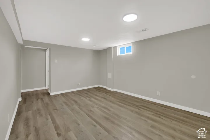 Neutral-toned interior space featuring wood-finish flooring and recessed LED lighting
