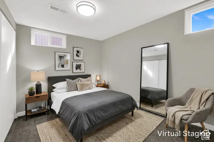 Neutral-toned interior featuring wall-to-wall carpeting, dual high-set windows, and a built-in sliding door closet